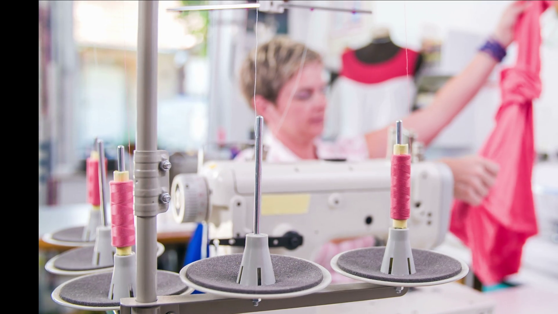 Sewing threads in front of tailor working on sewing machine