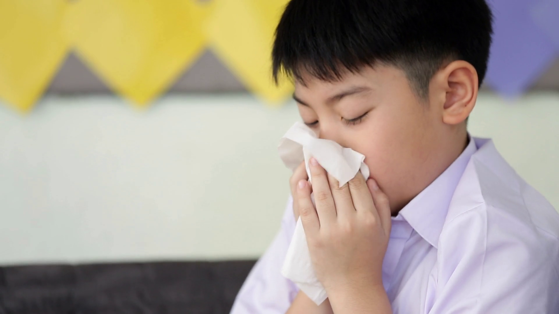 Little Asian child sick with flu sneezing and clean with tissue paper