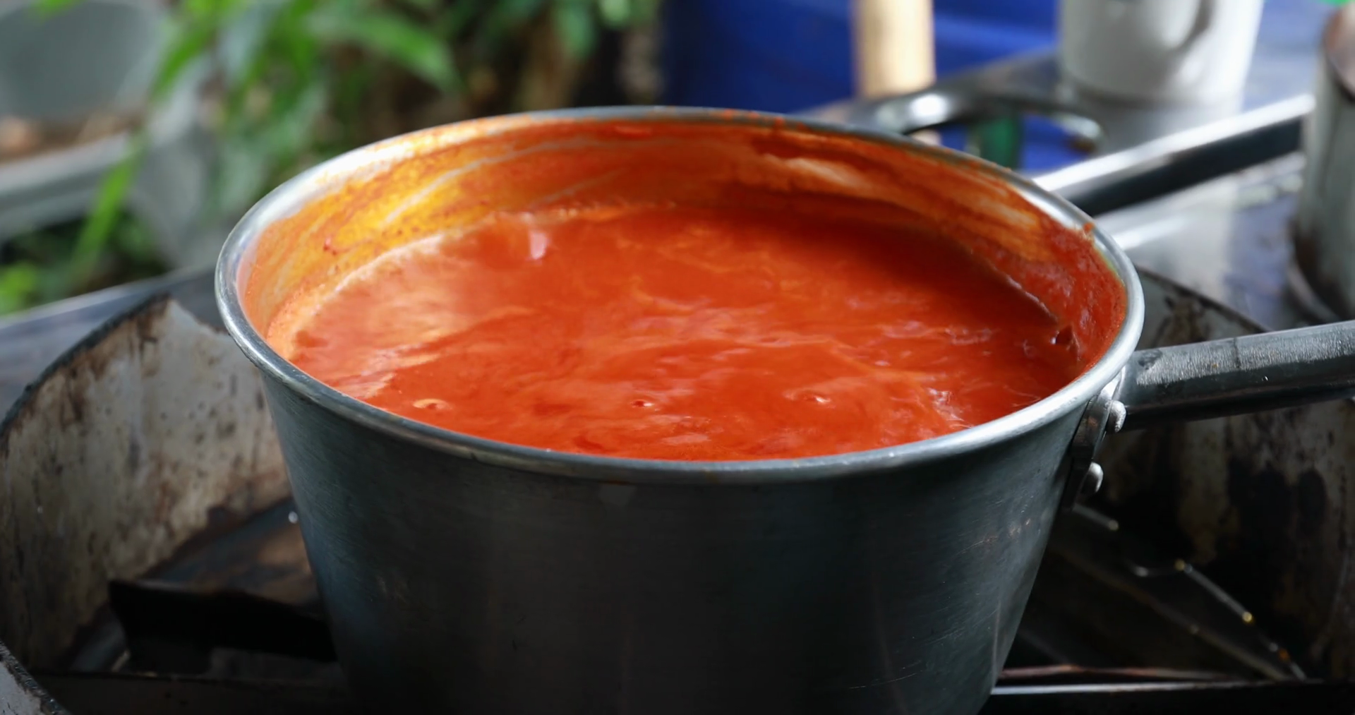 Shiny saucepan of boiling soup with foam on stove in kitchen, Jack
