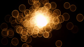 Abstract glow gold bokeh bubble particles flying on black background. Orange red gold bokeh