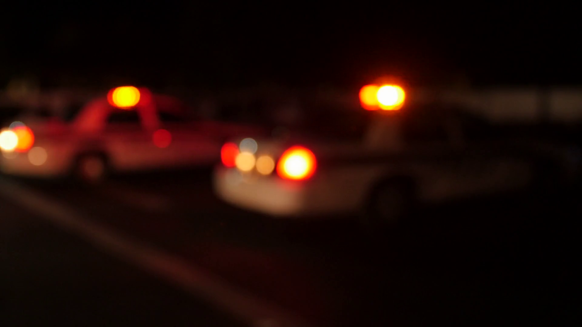 A police cars lights at an accident scene at night out of focus Stock