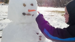 Boy Making A Fun Snowman In His Yard
