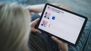 ZAPORIZHYA, UKRAINE - JUNE 7, 2024: Close up of Caucasian woman watching results of US presidential elections using digital tablet computer