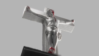 Artistic View of Crucifix Statue Representing Jesus Sacrifice, With Red Details Highlighting Pain and Redemption. Clean Background Enhances