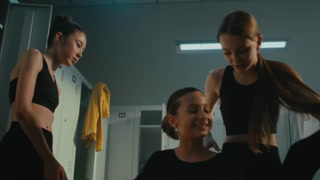 Inside Dressing Room With Metal Lockers, Group of Young Disciplined Dancers Perform Intense Split Stretch. Concept of Team Synergy, Unity