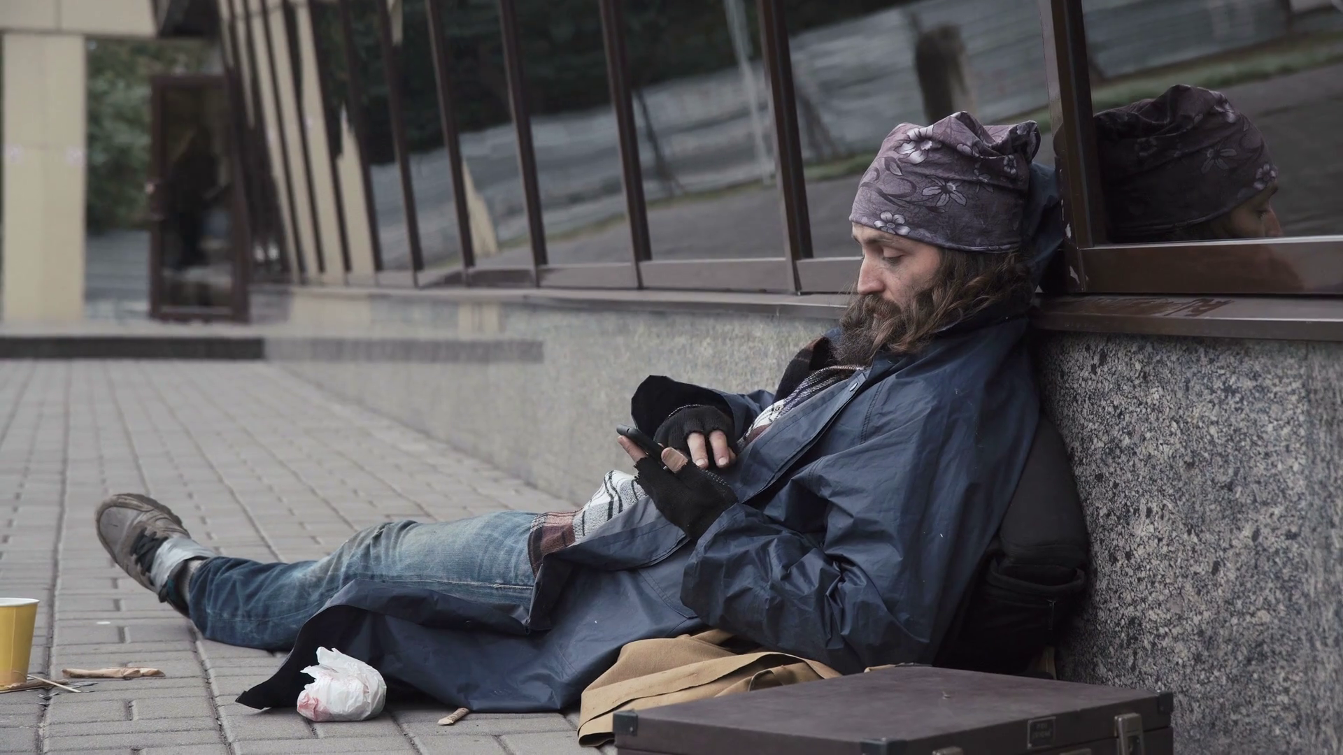 Cheerful Homeless Man Sitting On Pavement And Using Smartphone On Street Stock Video Footage Storyblocks