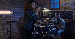Young woman performing with band in garage
