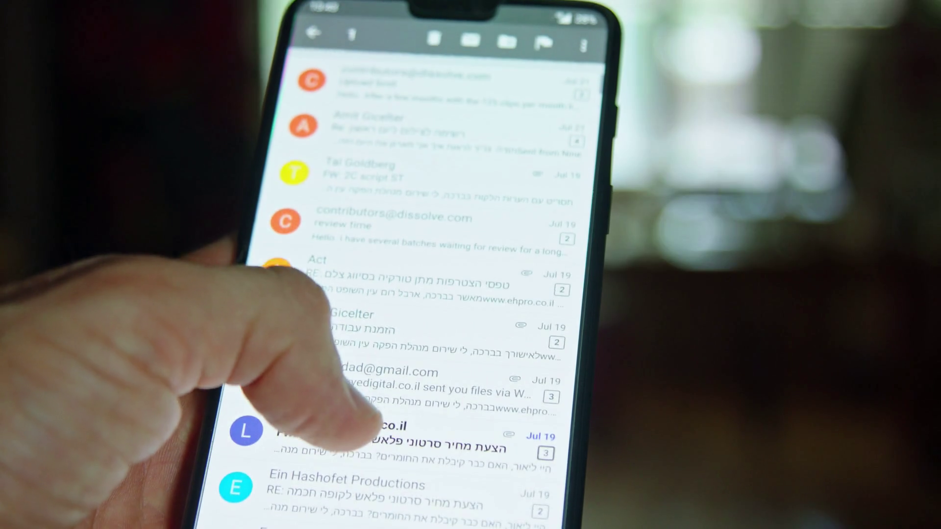 close up of hand browsing through emails on a smartphone screen Stock