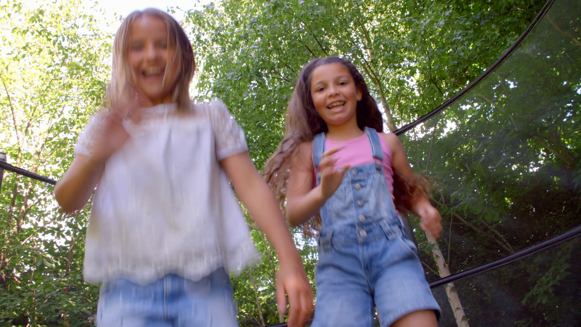 Two Girls Jumping On Trampoline Shot In Slow Motion Stock Video Footage