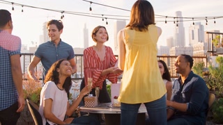 Friends Gathered On Rooftop Terrace To Celebrate Birthday With City Skyline In Background
