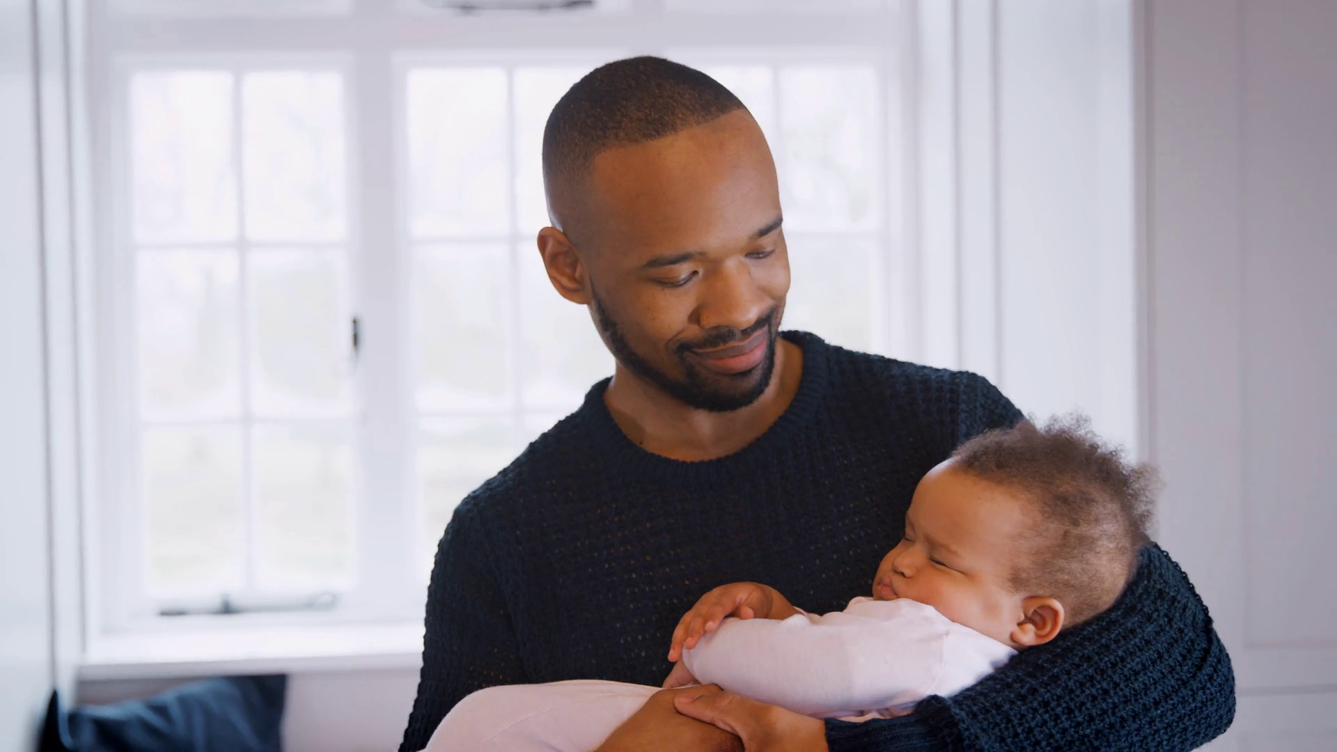 New Father Cuddling Sleeping Baby Girl In Nursery At Home Stock Video