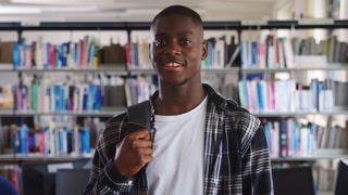 Portrait Of Male Student Standing In College Library