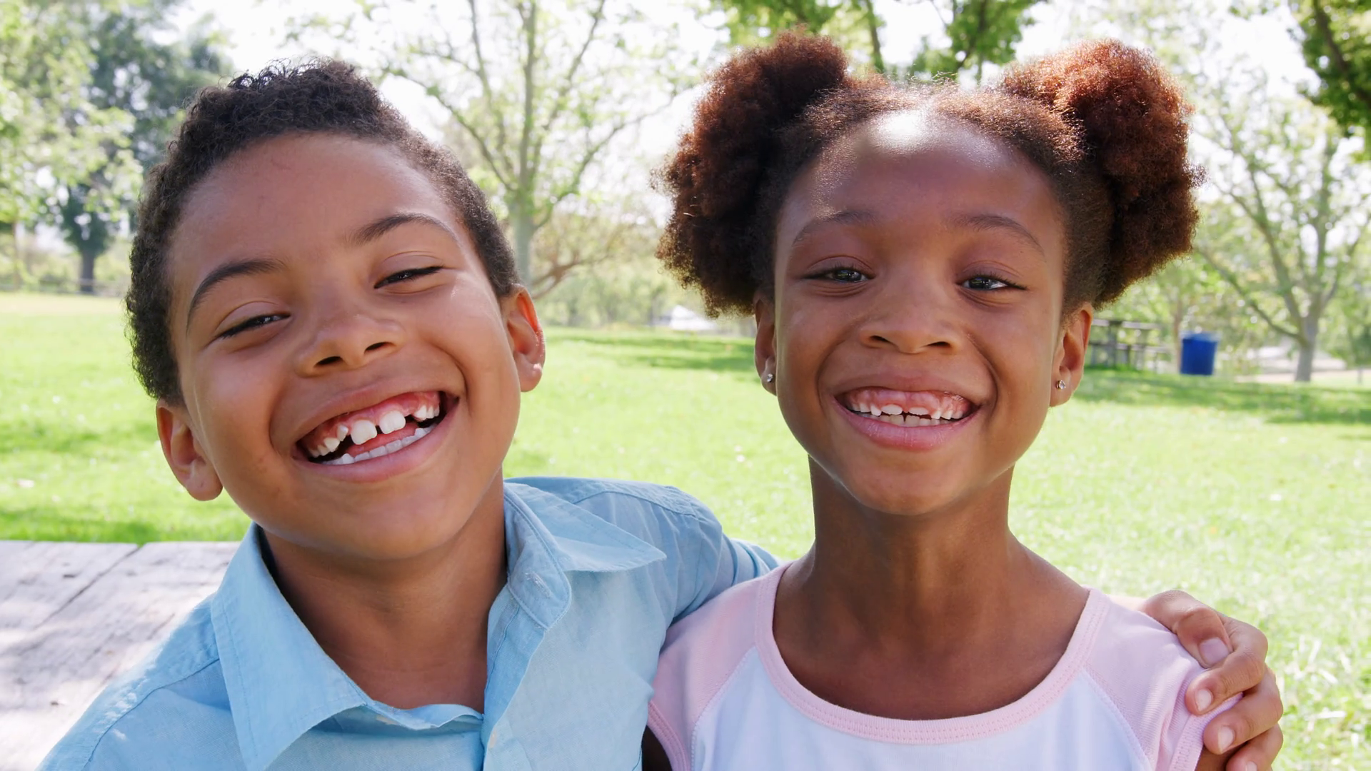 Slow Motion Portrait Of Smiling Brother And Sister Relaxing In Park ...