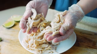 Presentation of the chicken sreded with the help of gloved hands. Romantic atmosphere
