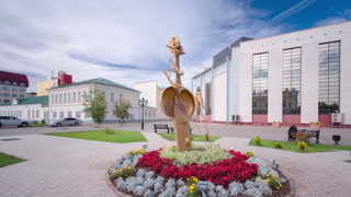 Sculpture with flowers and the building of Kazakh Drama Theatre in Uralsk timelapse hyperlapse. Sightseeing in the center of a small town