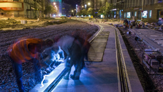 Tram rails at the stage of their installation and integration into concrete plates on the road night timelapse
