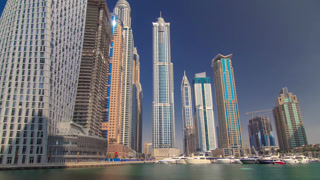 Dubai Marina with tallest skyscrapers and boats timelapse hyperlapse