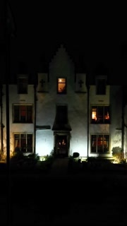 luxury property hotel countryhouse night dark facade flying towards estate haunted house halloween horror illuminated lighted movement straight drone aerial forward landmark