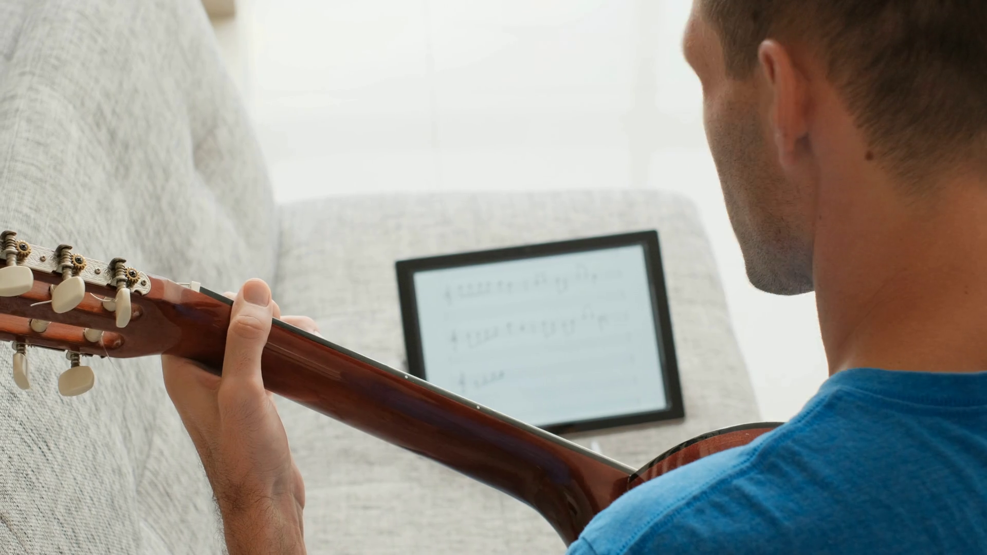 Music school student using music sheet with notes on ipad, learning how
