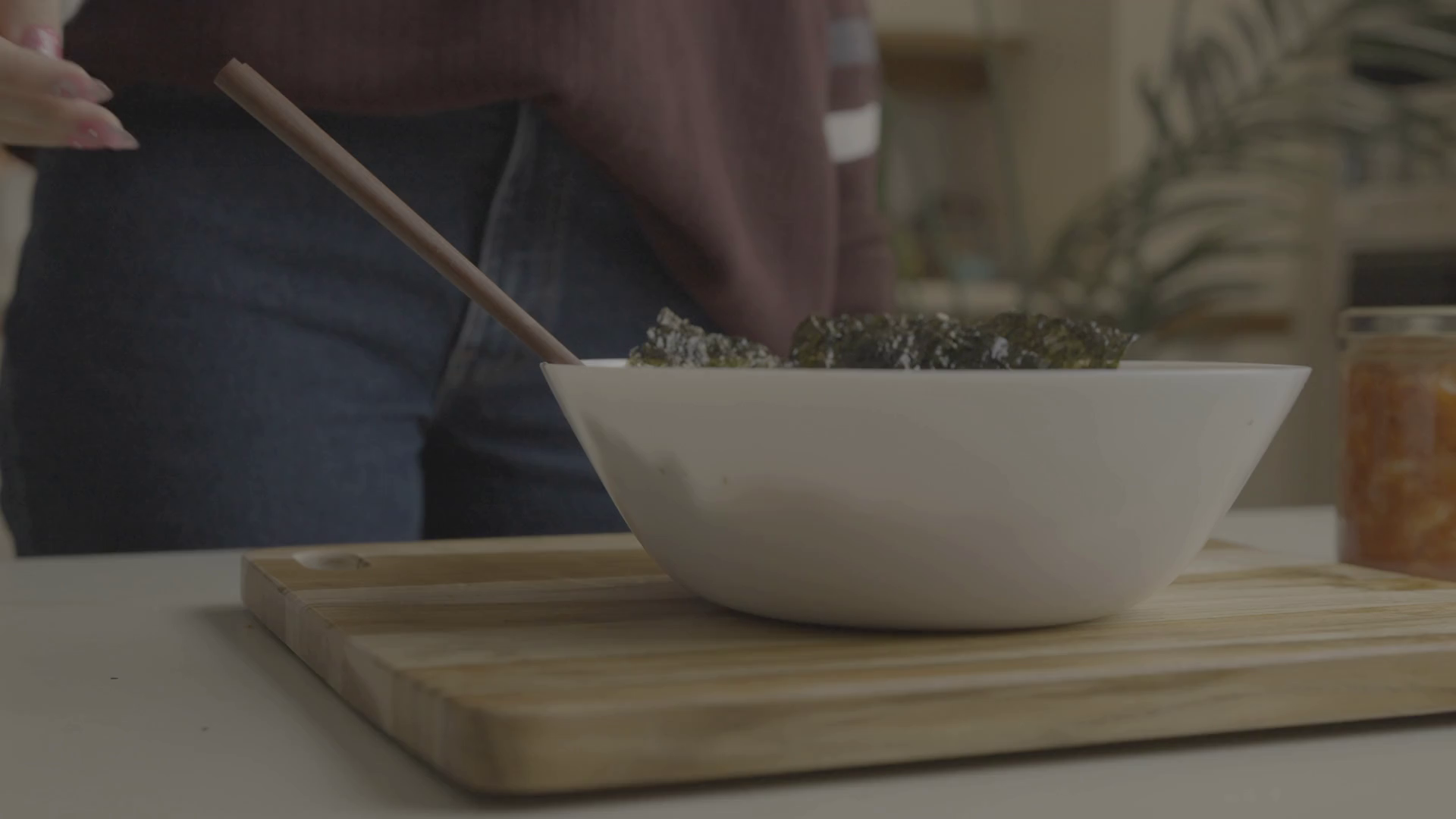 Slow motion shot of woman placing chopsticks into a poke bowl Stock