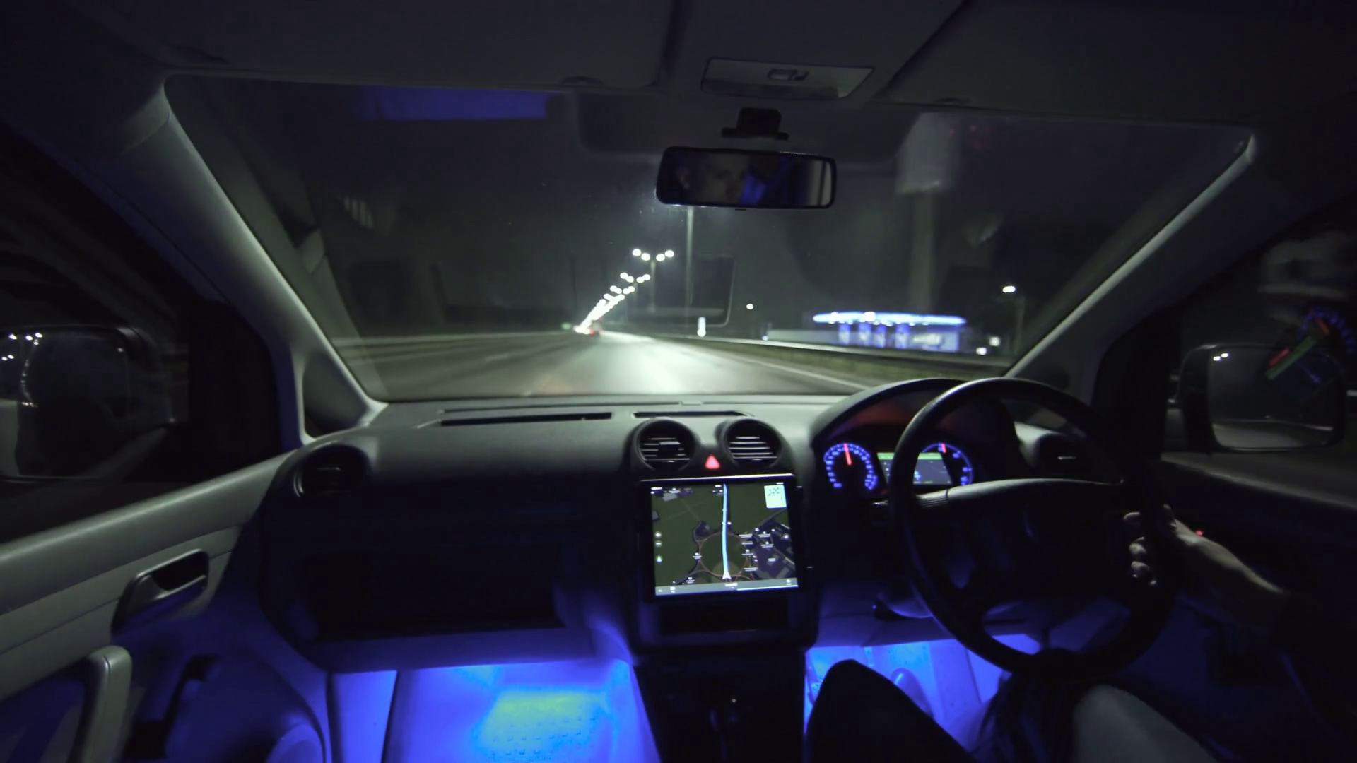 The man drive a car on the night highway. inside view. left side traffic, real time capture