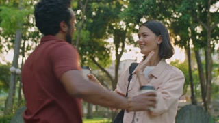 Medium shot of young woman holding to go coffee cup, telling goodbye to male friend and hugging him, then leaving park after walk on summer day