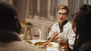 Hostess and friends enjoying holiday dinner party at home