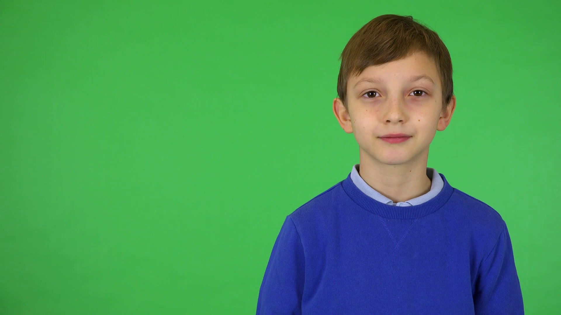 A young cute boy smiles at the camera green screen studio Stock Video