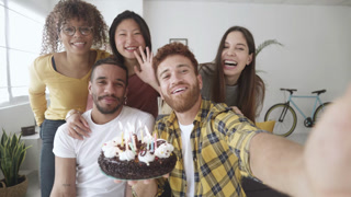Happy group of young people celebrating birthday through video call with friends
