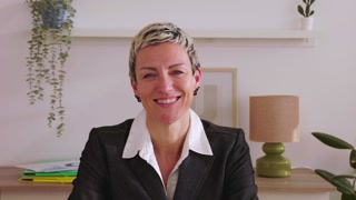 Confident portrait of middle aged businesswoman smiling at camera in the office