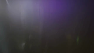 Very dark and subtle purple light leaks and lens flares moving slowly across a black background creating a mysterious moody atmosphere