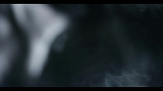 Ethereal white smoke swirling gracefully through a dark black background creating an abstract and mysterious atmosphere with soft fluid motion