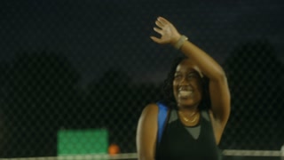 Handheld shot of black woman waving goodbye and smiling
