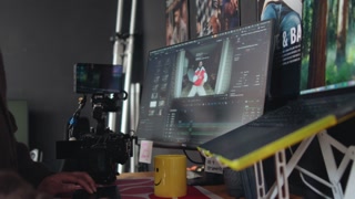 Handheld shot of editor’s monitor editing timeline on monitor