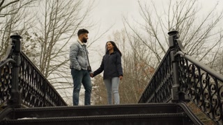 Low angle shot of biracial couple walking hand in hand and hugging a perfect love story