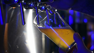Bartender pouring beer into glass with bubbles close up