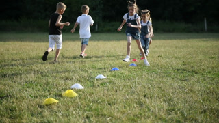 Young kids have fun by running through the obstacles on the ground of field