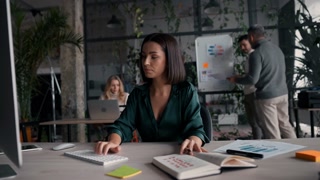 Focused caucasian woman wearing stylish casual shirt using pc computer for work sitting in the modern office
