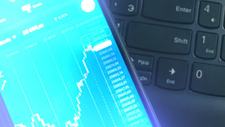 Live price chart for Bitcoin on background of a keyboard