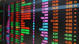 Stock market data displayed on a screen showing financial figures and investments