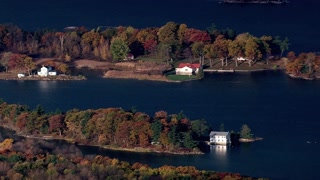 Scenic aerial view of islands with autumn foliage and houses on a tranquil lake