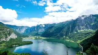 Hallstatt lake is surrounded by mountains and forests under a cloudy sky