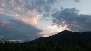 Dramatic sunset over a mountain range with clouds creating a scenic landscape
