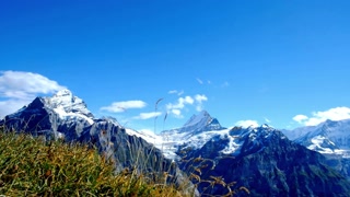 Scenic view of snow capped mountains against a clear blue sky on sunny day