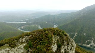 Serene vista of a river winding through lush green mountains on a cloudy day view