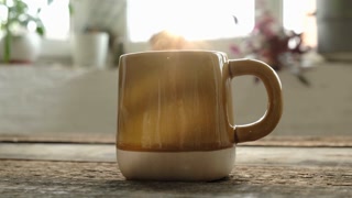 Mug of hot coffee on kitchen wooden table. Morning breakfast with coffee cup. Start of the day, energy boost.