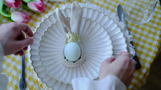 Woman setting table for Easter celebration. Overhead shot.