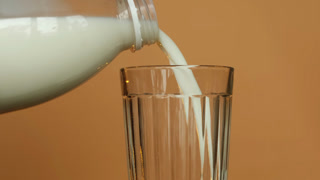 Pouring milk into a transparent glass