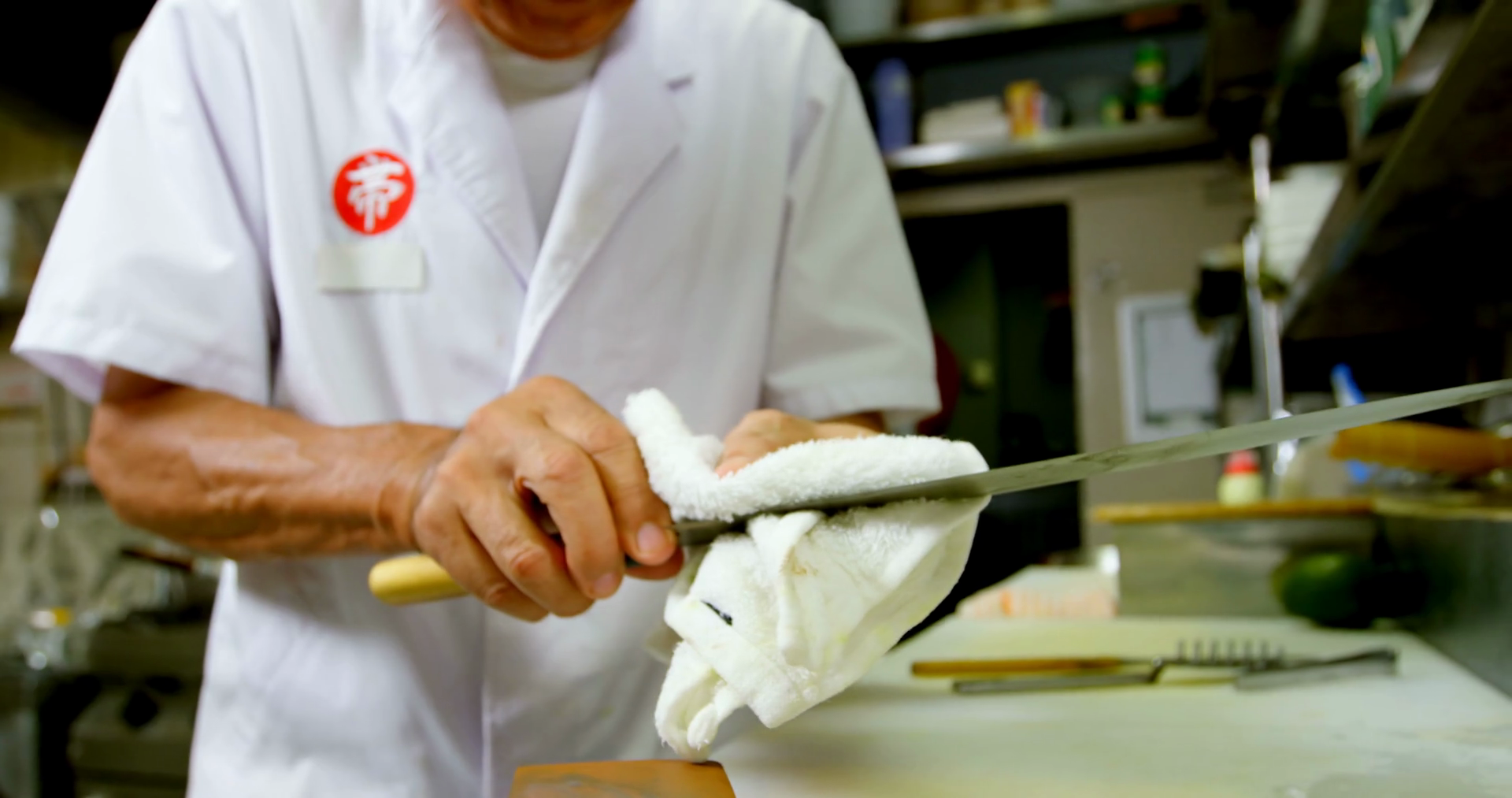 Male Chef Cleaning Knife With Rag In Kitchen Stock Footage SBV