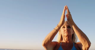 Disabled woman performing yoga in the beach 4k